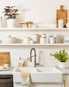 a white kitchen sink sitting under a window next to a dishwasher and oven