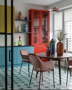 a dining room with colorful cabinets and chairs