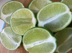 limes are cut in half on a cutting board