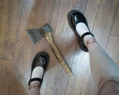 a person standing on top of a wooden floor next to a hammer