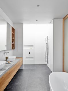 a large bathroom with two sinks and a bathtub in the middle of the room