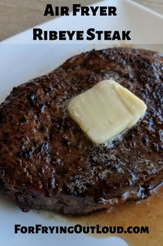 the steak is covered with butter and sits on a white plate, ready to be eaten