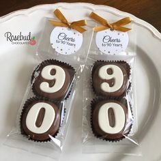 two chocolates with white frosting in the shape of numbers are on a plate