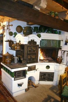 an old fashioned kitchen with many pots and pans on the stove top, along with other appliances