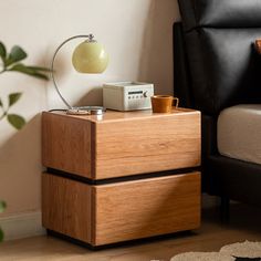 a nightstand with two drawers next to a couch