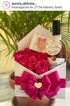 a bottle of wine and some roses in a box