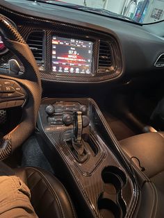 the interior of a sports car with steering wheel, dashboard and display screen showing information