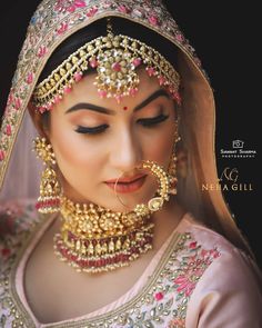 a woman in a bridal outfit with jewelry on her face