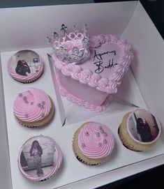 a box filled with pink cupcakes covered in frosting and topped with a tiara