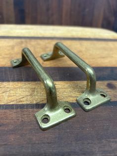 two metal handles on a wooden board