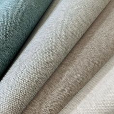 several different colors of fabric on top of each other, including blue and green tones