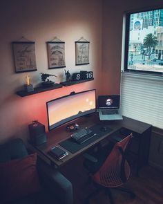 a laptop computer sitting on top of a wooden desk next to a monitor and keyboard