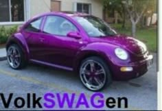 a purple car parked in front of a house with the words volkswagen on it