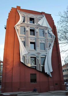 a building with a large mirror on the side of it's face and windows