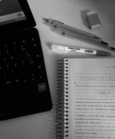 an open notebook and pen sitting on top of a desk