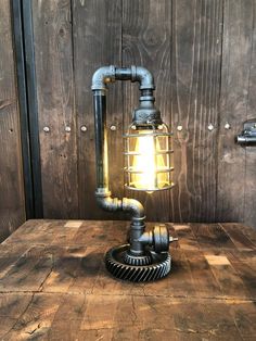 an industrial style lamp sitting on top of a wooden table