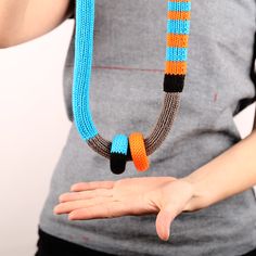 a woman is holding a beaded necklace in her hand and wearing it as a bracelet