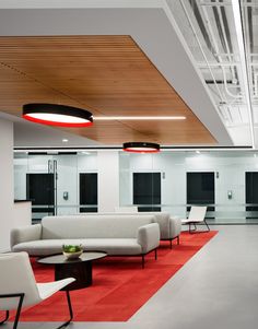 an office with white couches and red carpet