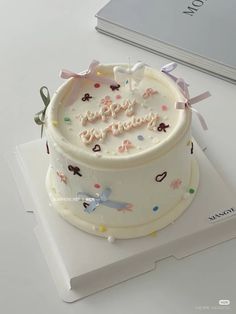 a white birthday cake sitting on top of a table