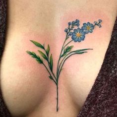 a close up of a woman's breast with blue flowers on her left side