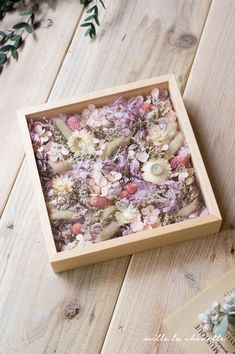 a wooden box filled with shells and flowers