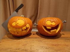 two pumpkins with faces carved into them