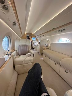 the inside of an airplane with seats and couches on each side, looking down at the floor