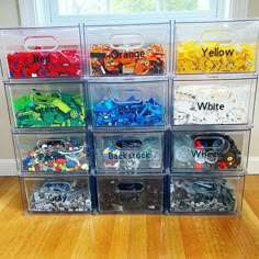 a stack of plastic bins filled with lots of different types of toy cars and toys