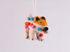 an ornament hanging from a string with a dog on it's back