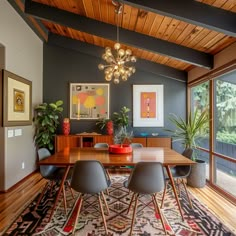 a dining room table surrounded by chairs and plants