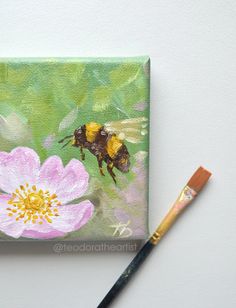 a painting of a bee on a flower with a paintbrush next to it,