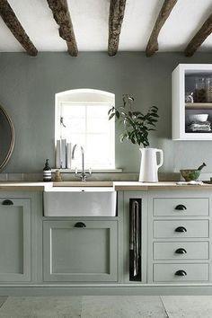 a kitchen with green painted cabinets and white counter tops, including a dishwasher