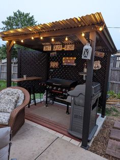 an outdoor bbq with lights on the roof and grilling area in the back yard