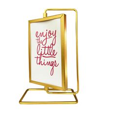 a white and gold framed sign with the words enjoy the little things written on it