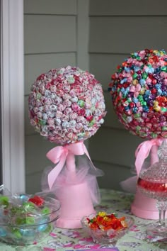 there are two candy balls on top of each other at the table with pink bows