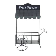 a black and white photo of a small cart with flowers on the top, sitting in front of a white background