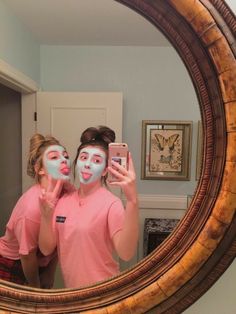 two girls with face paint in front of a mirror