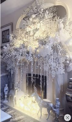 a living room filled with lots of white furniture and christmas decorations hanging from the ceiling