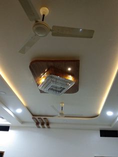 an empty room with white walls and ceiling fans on the ceiling is lit by recessed lights