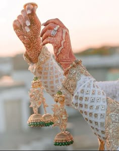 a close up of a person wearing jewelry and holding something in their hand with both hands