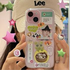 a person holding up a cell phone case with stickers on it