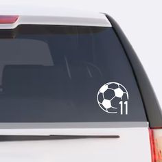 a white car with a soccer ball on it's back window and the number 11 sticker