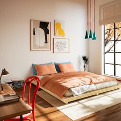 a bed sitting on top of a wooden floor next to a window