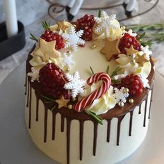 a white cake with chocolate icing, candy canes and stars on top is sitting on a plate