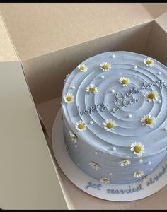 a cake in a box with daisies on it