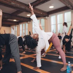 a group of people doing yoga in a large room