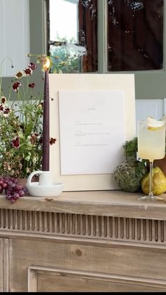 a table with flowers, fruit and candles on it