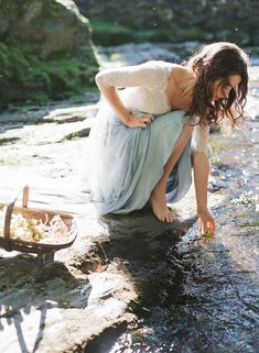 a woman is kneeling down in the water