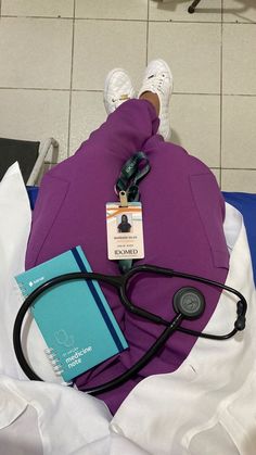 a doctor's stethoscope and book on top of a purple blanket