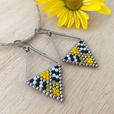 1" wide x 1.875" long from the top of the ear wire to the tip of the triangle beads. A dash of the 90's with spunky black and white stripes and a hint of sunny yellow bumblebee vibe -  built on a stainless steel triangle for a geometric (tarnish free) airy flair. A petite and modern take on a lively retro theme.. Heavy gauge sterling silver ear wires are sturdy and hypoallergenic. Handmade Geometric Yellow Jewelry, Triangle Beads, Beaded Jewelry Earrings, Seed Beading, Brick Stitch Earrings, Retro Theme, The Triangle, Sunny Yellow, Black And White Stripes